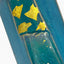 Gros plan des feuilles d’or appliquées sur la glaçure bleu persan du vase octogonal Hissan Tōen.