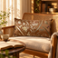 Coussin Sinapango Interiors Paris beige vieux rose en soierie de Nishijin à lotus et volutes, posé sur une chaise en rotin