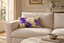 Coussin Sinapango Interiors Paris en obi Nishijin à grandes fleurs violines, posé sur un canapé à l’échelle 30 x 50 cm