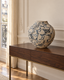 Vase en grès de Masafumi Fujihara à décor de pampres, sur une console dans un intérieur haussmannien — simulation.