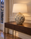 Simulation du vase à décor de pampres de Masafumi Fujihara monté en lampe avec abat-jour en lin ivoire, ambiance tamisée.