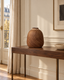 Vase aux oiseaux en grès brun de Watanabe Nobuo sur une console dans un intérieur haussmannien — mise en situation simulée.